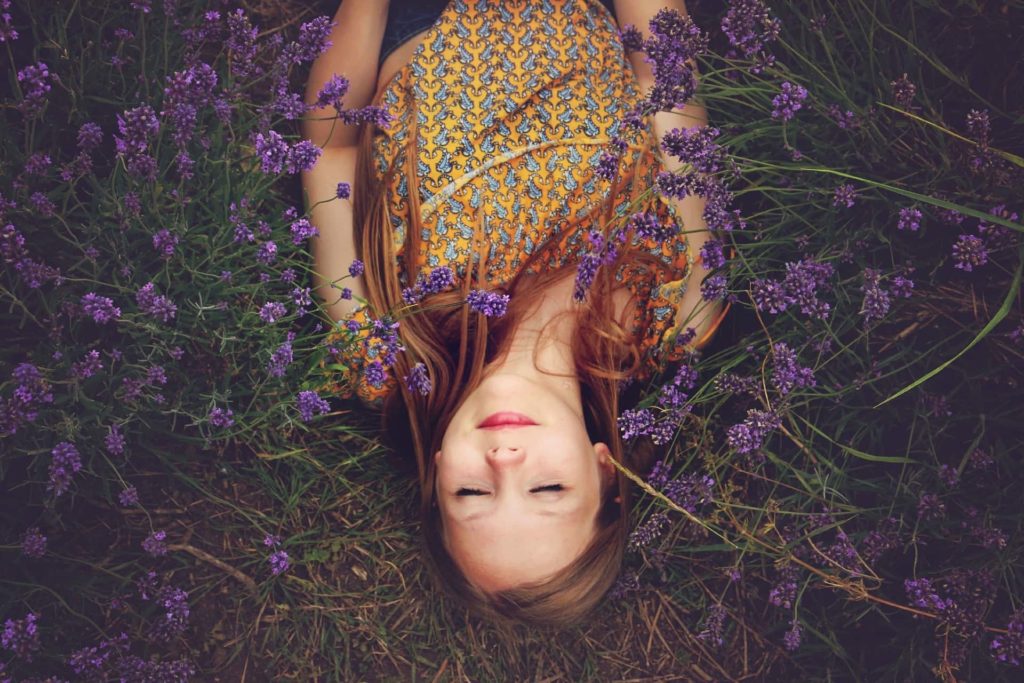 Woman practising mindfulness in a field of purple flowers