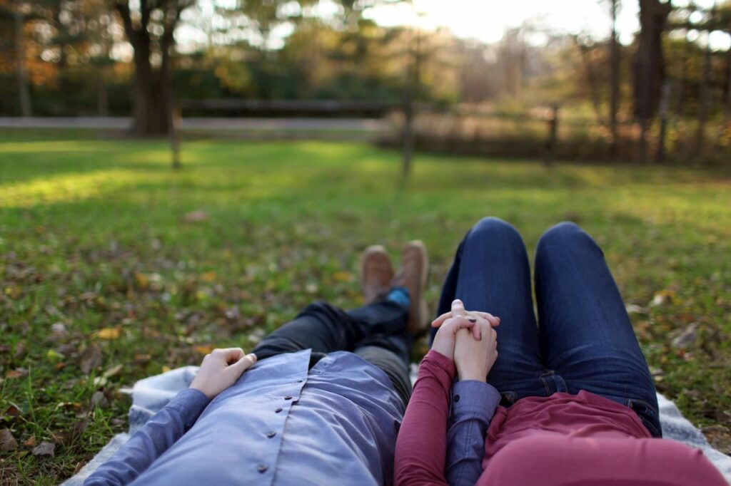 A couple lying side by side in a meadow