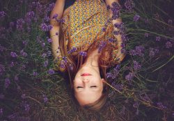 Woman practising mindfulness in a field of purple flowers